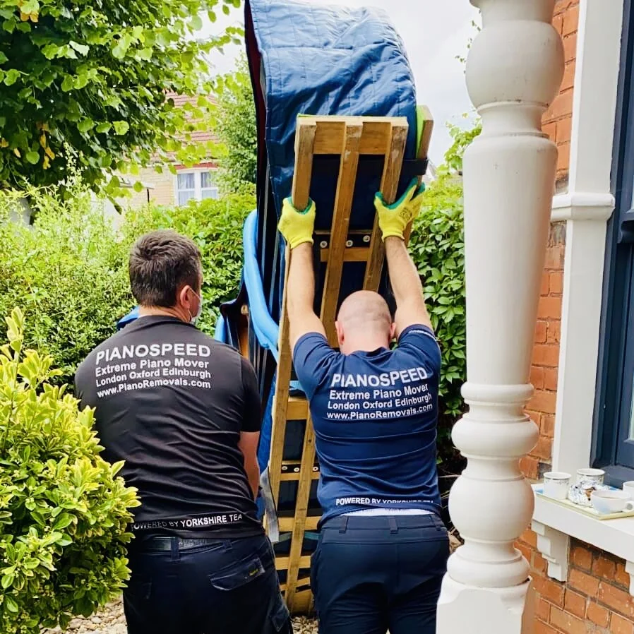 Specialist piano crew loading a piano for long-term storage collection